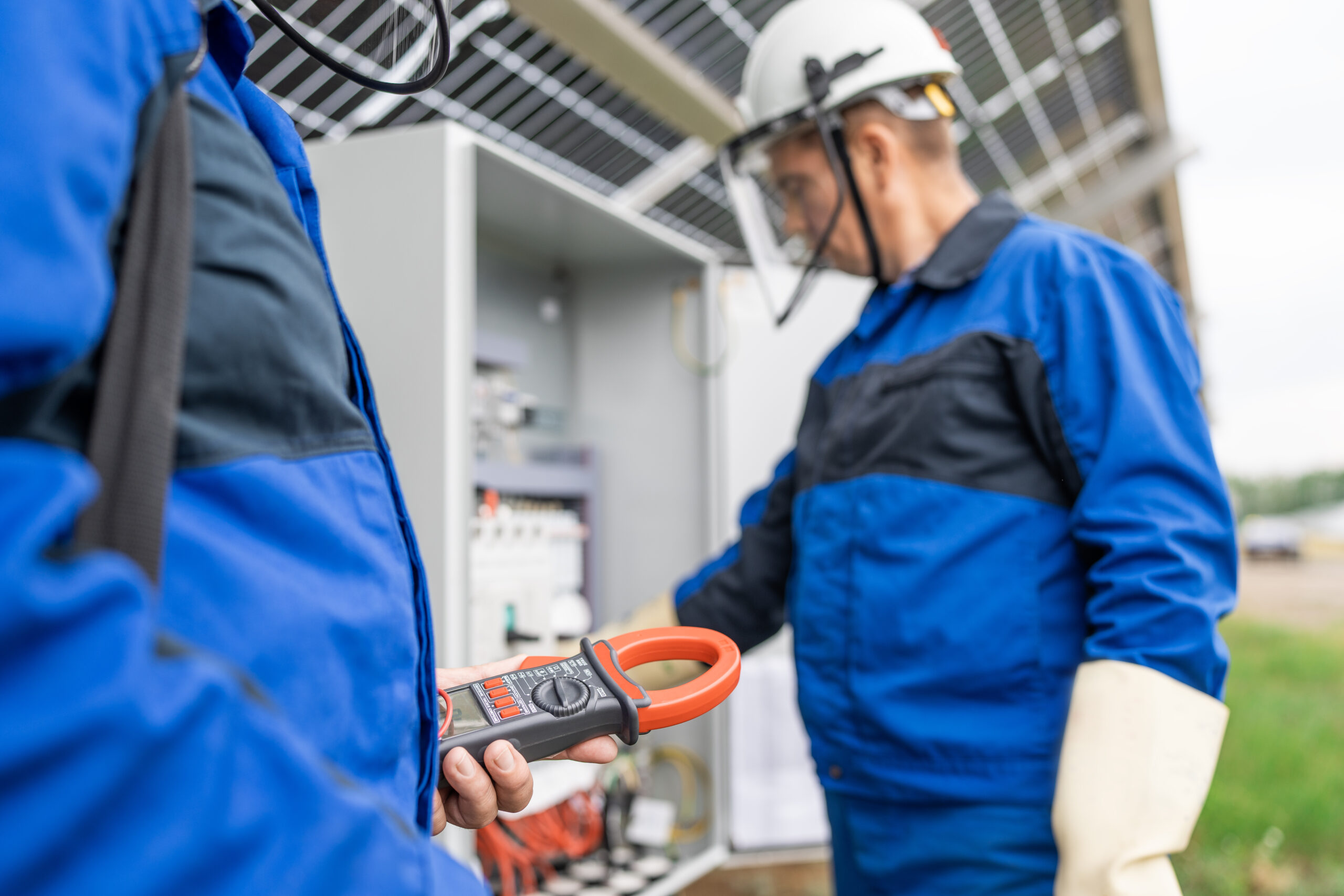 two service engineers electrician working checking transformer site solving problem scaled